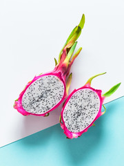 Creative flat layout with dragonfruit (pitaya or pitahaya) on two tone double color paper, white and blue mint background. Top view, flat lay of the fresh ripe fruit ready to eat.