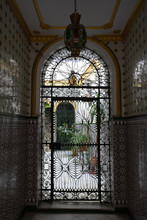 Iron Lace On Doors And Ceramic Tiles With Ornament At The Entrance To Traditional Patio Yards In Andalusia, Spain