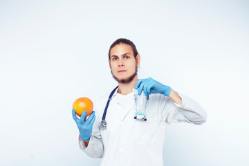 young pretty doctor with stethoscope holding fruits, vegetables and pills, healthy food care concept