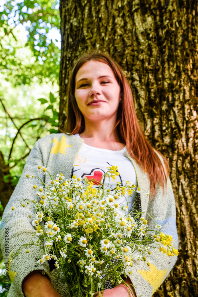 Young beautiful woman is standing in the forest with a bouquet o Stock ...