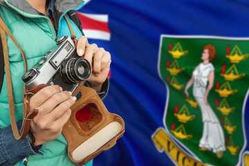 Wall Mural - British Virgin Islands photographer concept. Close-up adult woman holding retro camera on national flag background. Adventure and traveler theme.