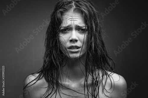 Fotomural Expressive black white portrait of a young attractive girl with wet dark hair