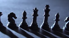 Closeup Track Shot Of Black Chess Pieces In Low Dramatic Lighting - 4K.