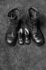 Two pairs of  black shoes on the concrete background