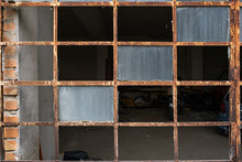 The Broken Windows And Rusting Frame Of A Door Leading Into A Garage, Nobody In The Image