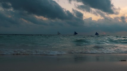 Sticker - Amazing colors of tropical sunset. Sail boats silhouettes floating on ocean horizon. Ocean waves wash the sand. Boracay island, Philippines.