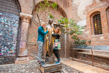 Selfie Photo Of Couple Man And Woman Hold Statue Of Juliet Balcony In City Verona Italy. Travel Concept