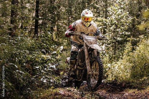 Mata magnetyczna motocross enduro racer jedzie na brudnym leśnym szlaku