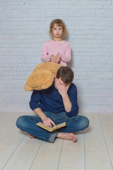 father and daughter against a white brick wall