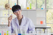 Asian male scientist stand and smile in lab room..