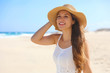 © zigres - Happy cheerful young woman with straw hat walking on the beach