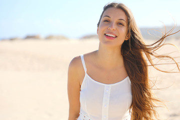 Wall Mural - Close up of smiling brazilian girl on the beach in summer holidays looking at camera