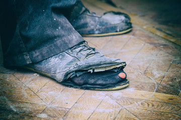 Old torn boots on the man's feet