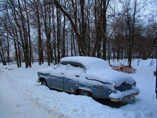 vintage russian car covered with snow and abandoned