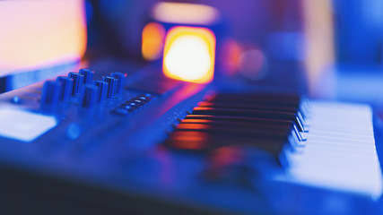 Poster - Midi keyboard in home music studio in blue neon light. Shallow depth of field
