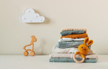 Wall Mural - Organic cotton baby clothes on the shelf near baby toys