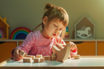 Beautiful little girl playing with wooden toy galaxy balancer