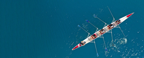 Wall Mural - Aerial drone ultra wide photo with copy space of sport canoe with young team of athletes practising in deep blue open ocean sea