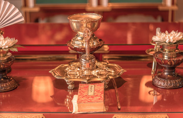 Prayer room of Gokokuji temple with sutra booklet, Gokorei bell and golden diamond Buddhist sword symbol of the indestructible and the immutable with two lotus flowers.