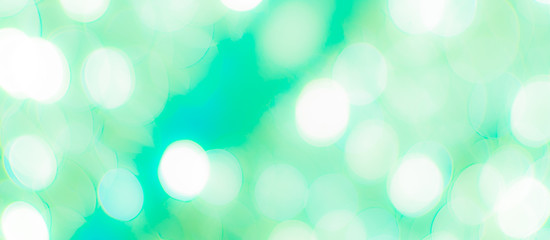 Wall Mural - Abstract Bokeh Blue and green background of defocused glittering lights. Christmas, Party, New Year, luxurious background pattern concept. banner.