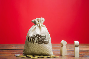 Money bag and two wooden figures of people. Business and finance concept. Businessmen are discussing the company's profit. Search for sources of funding. Business planning. Revenue analysis.