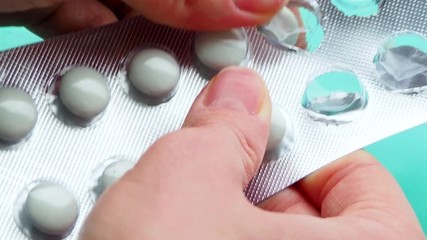 Wall Mural - The woman takes a lot of pills out of pack. The concept of overdose, medicine and health care. A dose for death. Excess of drugs in modern treatment. Capsules on a blue background