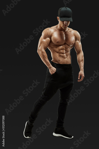 Leinwand Poster Full-length portrait of shirtless male bodybuilder with muscular physique posing with muscular build strong abs showing