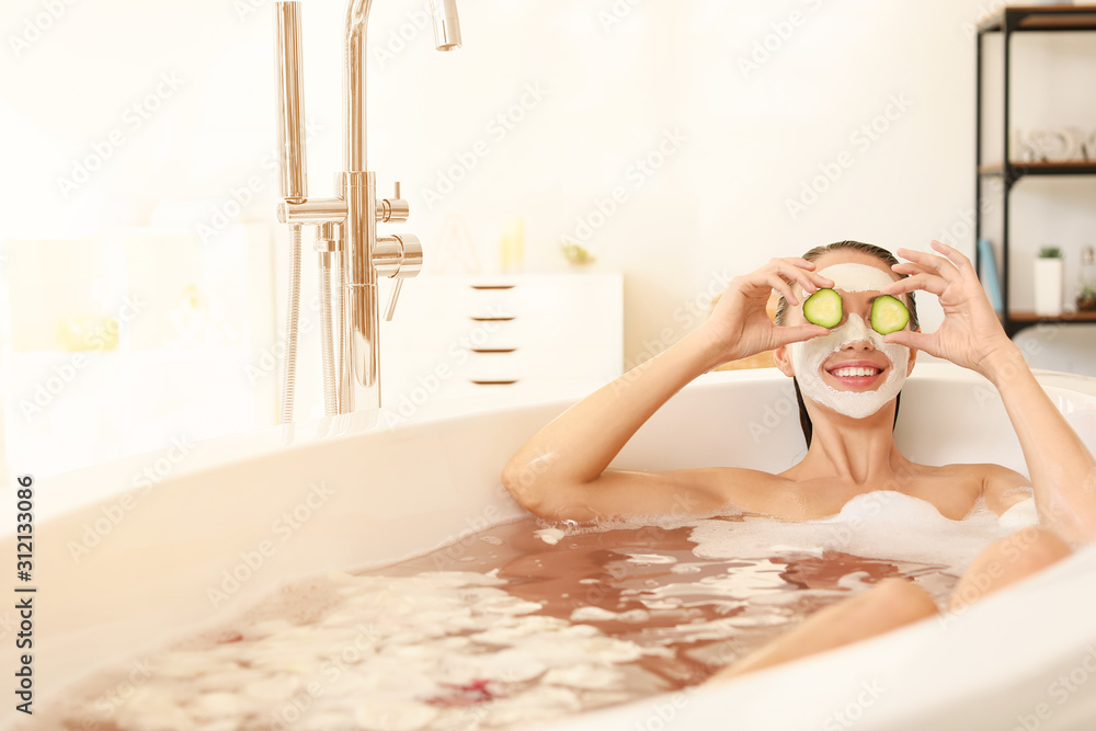 Beautiful young woman having fun in bathtub