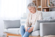 © Pixel-Shot - Senior woman suffering from pain in knee at home