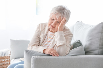 Sticker - Senior woman suffering from headache at home