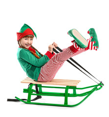 Sticker - Little girl in costume of elf sitting on sledge against white background