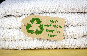 Wall Mural - Recycle clothes icon on recycled card label, made with 100% Recycled fabric text. Sustainable fashion and ethical shopping concept