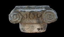 Ancient Greek Ionic Style Basalt Stone Capital From The Katzrin Open Air Museum In The Golan Heights In Israel Isolated On A Black Background