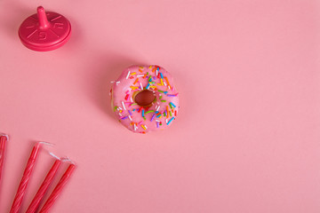 Wall Mural - colorful doughnuts dreidel candles pink background studio