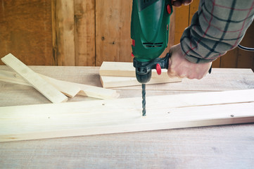 Making hole into the wood with drill.