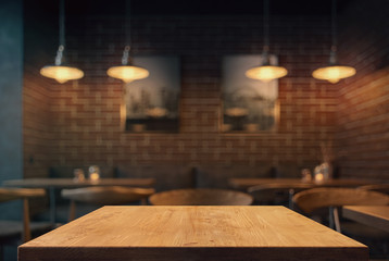 Empty tabletop in the coffe shop at night over defocused background with copy space