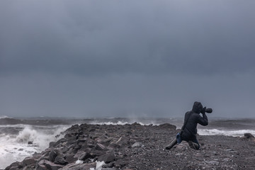 Photographer photographing the ocean during a storm in Iceland. long exposure