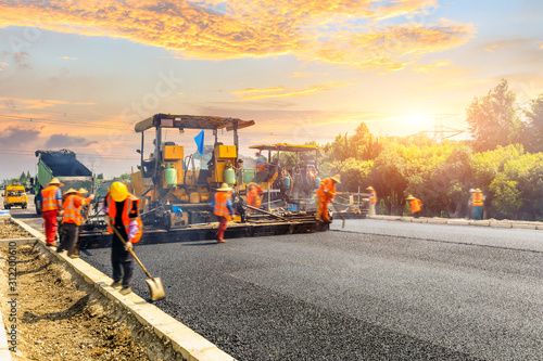Cuadros en Lienzo Construction site is laying new asphalt road pavement,road construction workers and road construction machinery scene