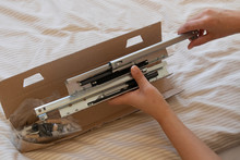 Assembling Furniture At Home By A Woman With The Detail Of Opening A Box With Screws And Etc. 