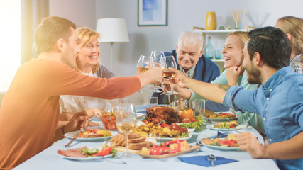 Big Family and Friends Celebration at Home, Diverse Group of Children, Young Adults and Old People Gathered at the Table have Fun Conversation. Clinking Glasses and Making Toast.