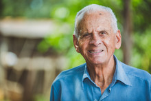 Portrait Of Smiling Beautiful Older Male Farmer. Elderly Man At Farm In Summer Day. Gardening Activity. Brazilian Elderly Man.