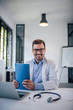 © bnenin - Portrait of a cheerful handsome general practitioner at work.