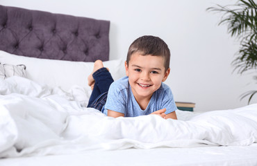 Wall Mural - Cute little boy lying on bed at home