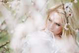 Fototapeta Do akwarium - beautiful young woman with long blonde hair in blossom park