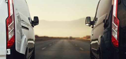 two commercial vans speeding by highway