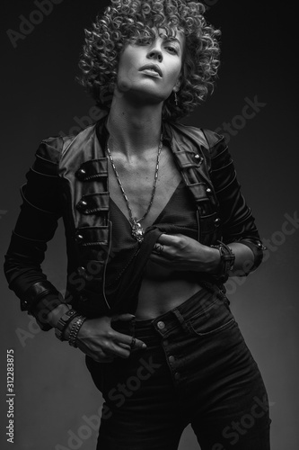 Young Attractive Sexy Girl With Curly Hair In The Form Of A Rock