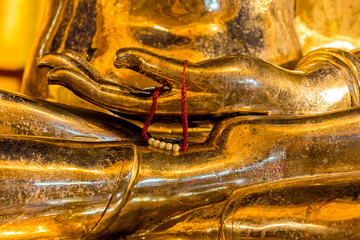 Closeup of a golden buddha's hand with offering