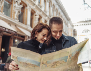 Wall Mural - Beautiful couple on vacation using paper city map for directions. Travel vacation, leisure recreation lifestyle.