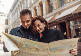 Wall Mural - Beautiful couple on vacation using paper city map for directions. Travel vacation, leisure recreation lifestyle.