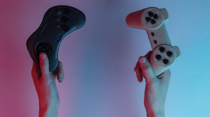 Wall Mural - Gamer concept. Hands holding gamepads. Creative pop art pink blue neon color. Trendy gradient illumination. Night light